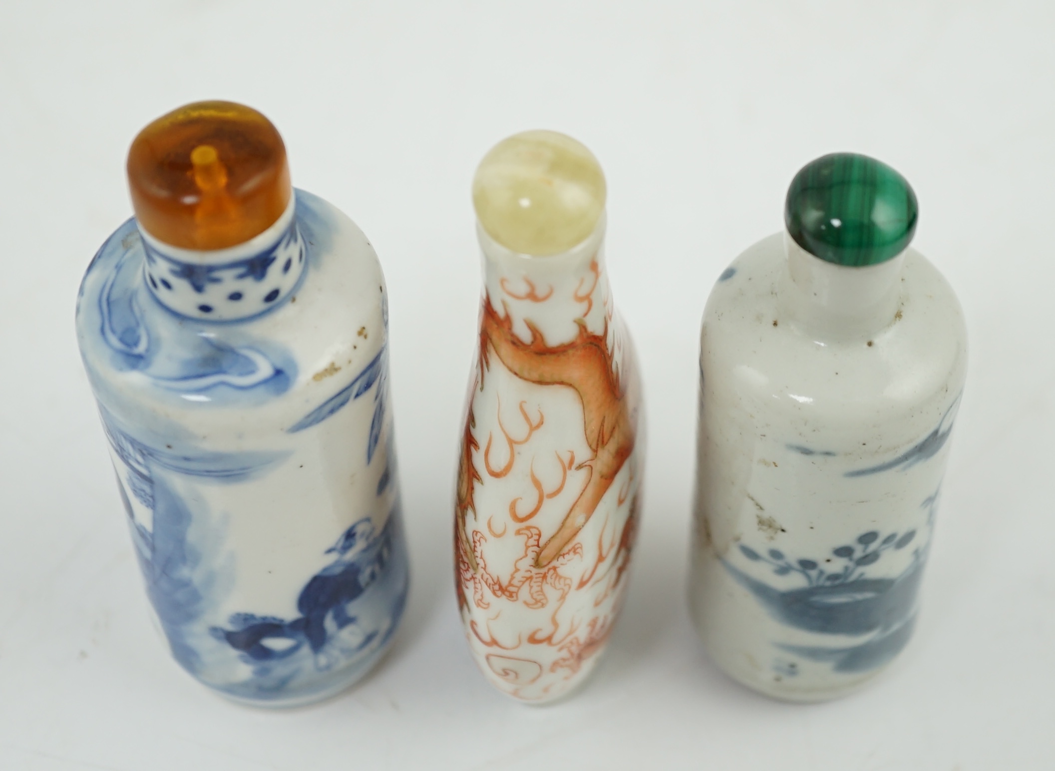 A Chinese iron red enamelled ‘dragon’ snuff bottle, Tongzhi mark and of the period (1862-74), together with two Chinese blue and white cylindrical snuff bottles, 19th century